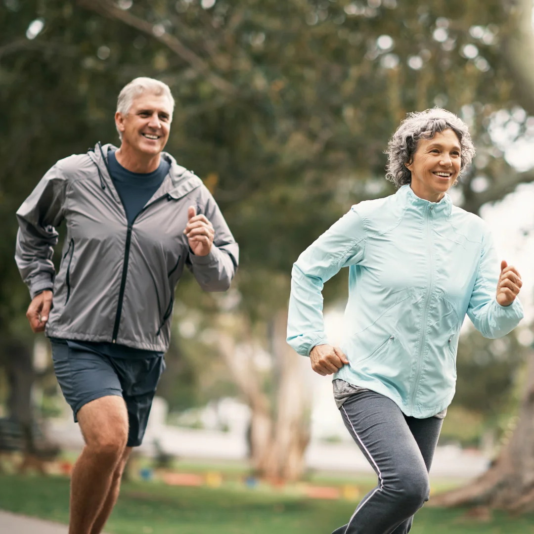 Uma imagem de um homem e uma mulher caminhando de mãos dadas em um parque, com árvores e flores ao redor. Eles estão sorrindo e olhando um para o outro, demonstrando felicidade e harmonia. A imagem representa o bem-estar e o equilíbrio emocional que podem ser alcançados com uma abordagem médica que inclui fitocan4bin0ides e acupuntura, duas terapias integrativas que podem trazer muitos benefícios para a saúde.